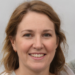 Joyful white adult female with medium  brown hair and grey eyes