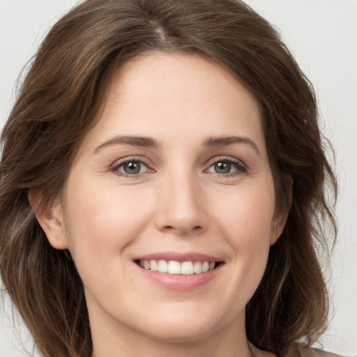 Joyful white young-adult female with long  brown hair and grey eyes