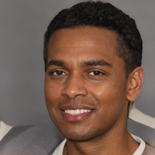 Joyful black young-adult male with short  brown hair and brown eyes
