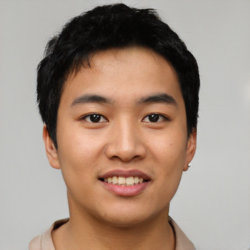 Joyful asian young-adult male with short  black hair and brown eyes