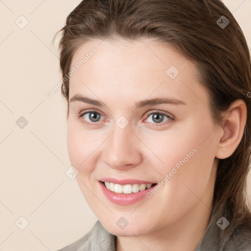 Joyful white young-adult female with medium  brown hair and grey eyes