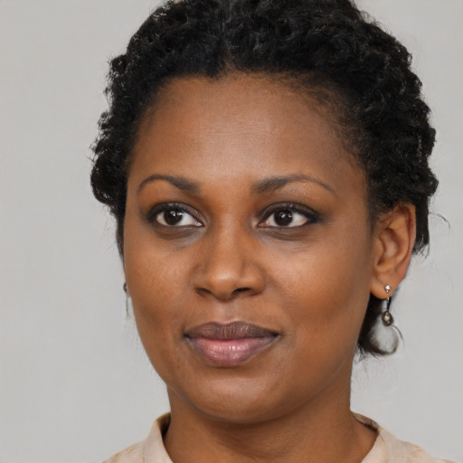Joyful black adult female with short  black hair and brown eyes