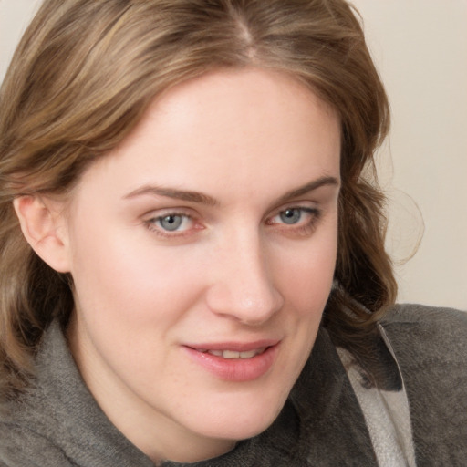 Joyful white young-adult female with medium  brown hair and blue eyes