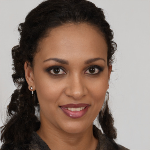 Joyful black young-adult female with long  brown hair and brown eyes