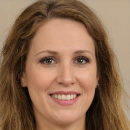 Joyful white young-adult female with long  brown hair and green eyes