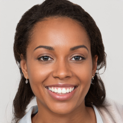 Joyful black young-adult female with medium  brown hair and brown eyes