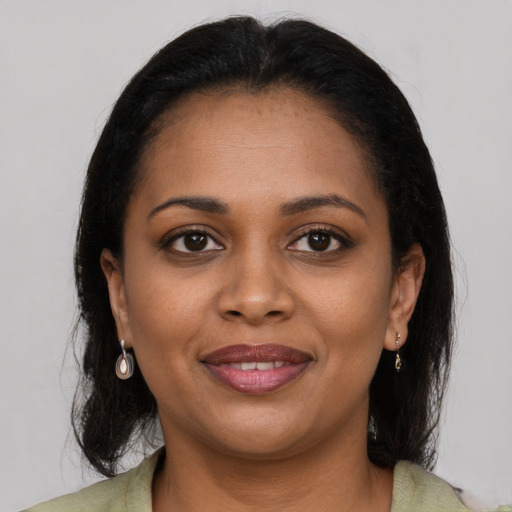 Joyful black young-adult female with medium  brown hair and brown eyes