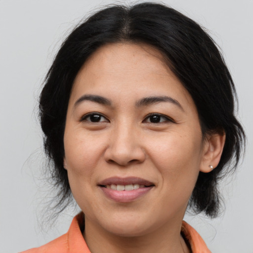 Joyful asian adult female with medium  brown hair and brown eyes