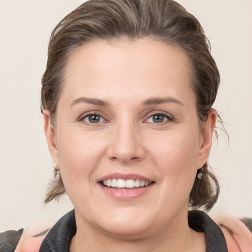 Joyful white young-adult female with medium  brown hair and grey eyes