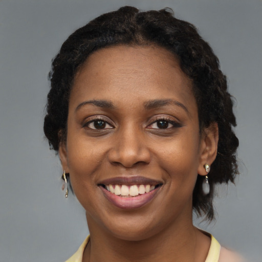 Joyful black young-adult female with medium  brown hair and brown eyes