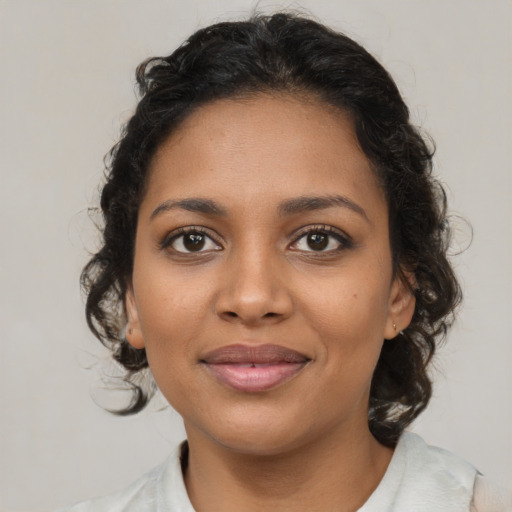 Joyful black young-adult female with medium  brown hair and brown eyes