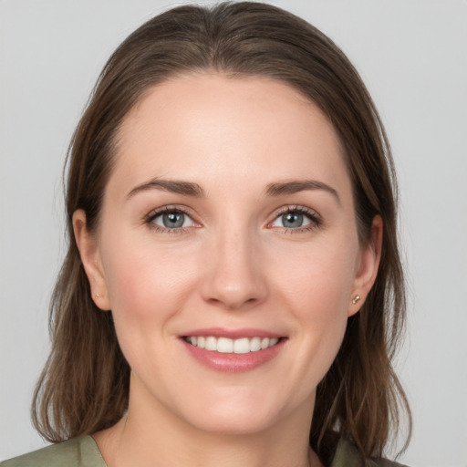 Joyful white young-adult female with medium  brown hair and grey eyes