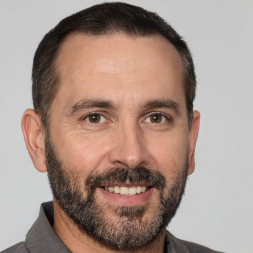 Joyful white adult male with short  black hair and brown eyes