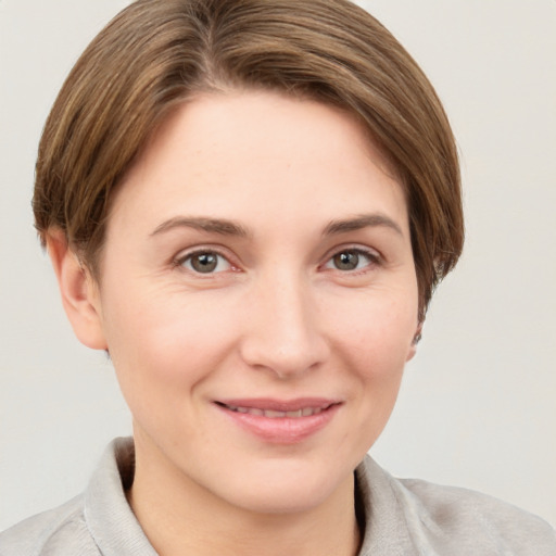 Joyful white young-adult female with short  brown hair and grey eyes