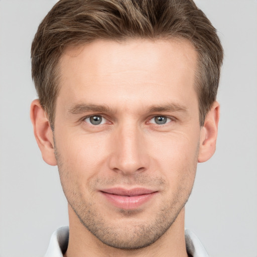 Joyful white young-adult male with short  brown hair and grey eyes