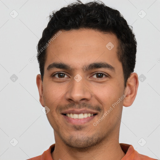 Joyful latino young-adult male with short  brown hair and brown eyes