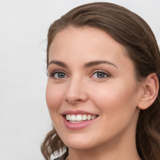 Joyful white young-adult female with long  brown hair and grey eyes