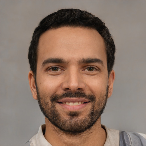 Joyful white young-adult male with short  black hair and brown eyes