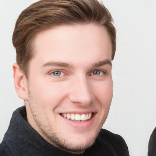 Joyful white young-adult male with short  brown hair and blue eyes