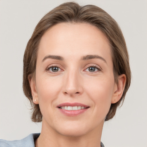 Joyful white young-adult female with medium  brown hair and grey eyes