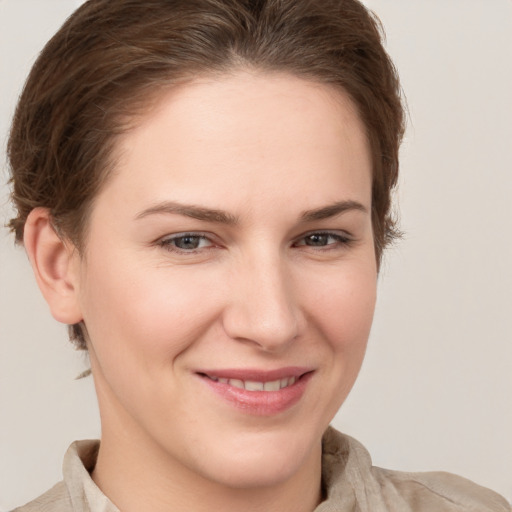 Joyful white young-adult female with short  brown hair and grey eyes