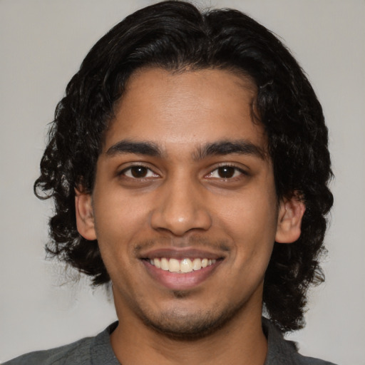 Joyful latino young-adult male with medium  black hair and brown eyes