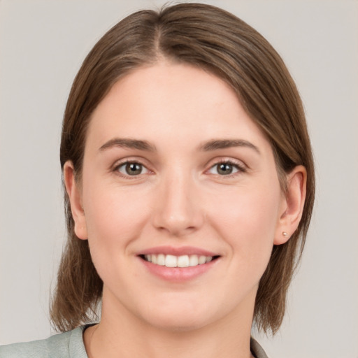 Joyful white young-adult female with medium  brown hair and grey eyes