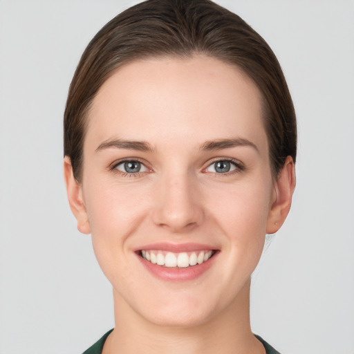 Joyful white young-adult female with short  brown hair and grey eyes