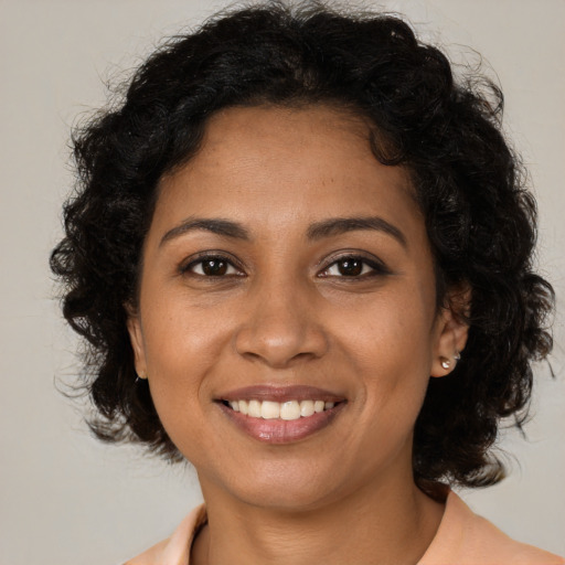 Joyful black young-adult female with medium  brown hair and brown eyes