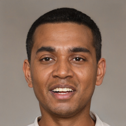 Joyful black young-adult male with short  black hair and brown eyes
