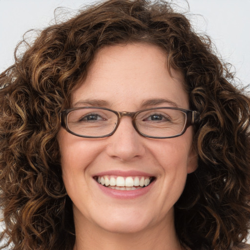 Joyful white adult female with long  brown hair and green eyes