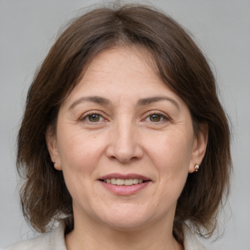 Joyful white adult female with medium  brown hair and brown eyes