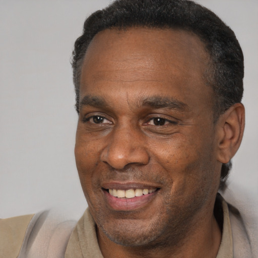 Joyful black adult male with short  brown hair and brown eyes