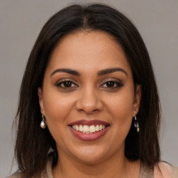 Joyful latino young-adult female with medium  brown hair and brown eyes