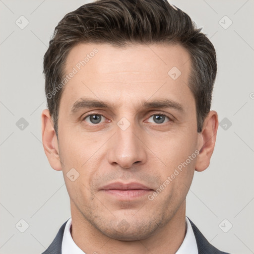 Joyful white young-adult male with short  brown hair and grey eyes