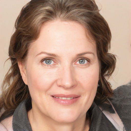 Joyful white adult female with medium  brown hair and blue eyes