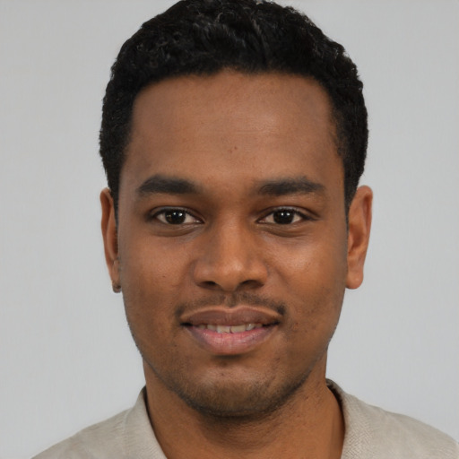 Joyful black young-adult male with short  black hair and brown eyes