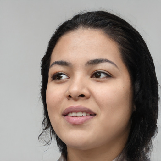 Joyful latino young-adult female with long  black hair and brown eyes