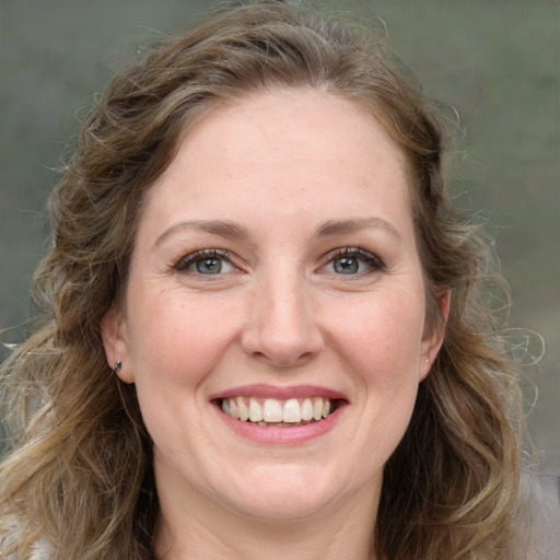 Joyful white adult female with long  brown hair and grey eyes