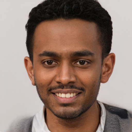 Joyful black young-adult male with short  black hair and brown eyes