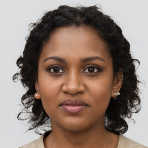 Joyful black young-adult female with long  brown hair and brown eyes