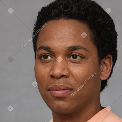 Joyful black young-adult male with short  black hair and brown eyes