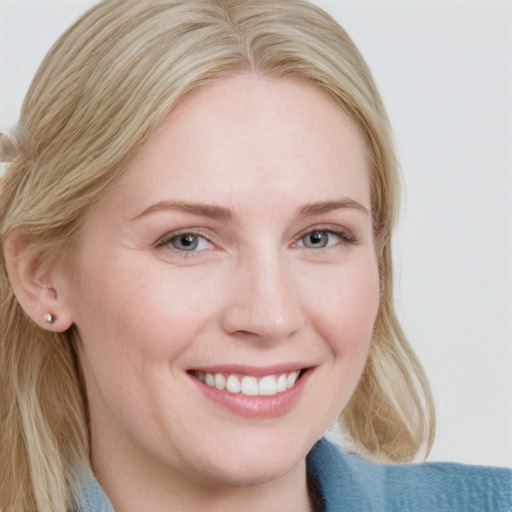 Joyful white young-adult female with medium  blond hair and blue eyes