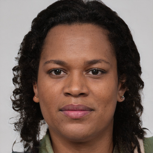 Joyful black adult female with long  brown hair and brown eyes