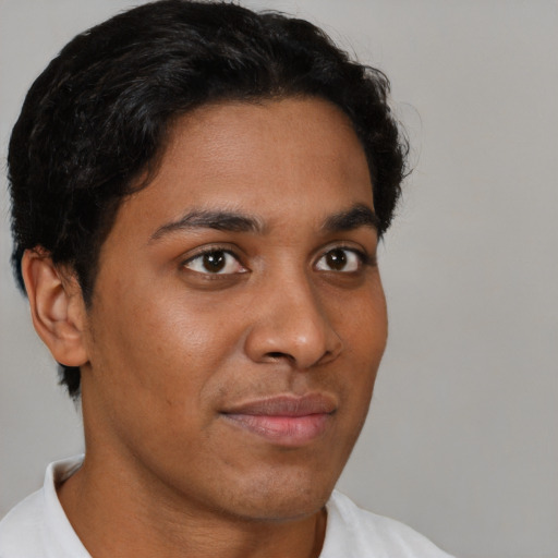 Joyful black young-adult male with short  brown hair and brown eyes