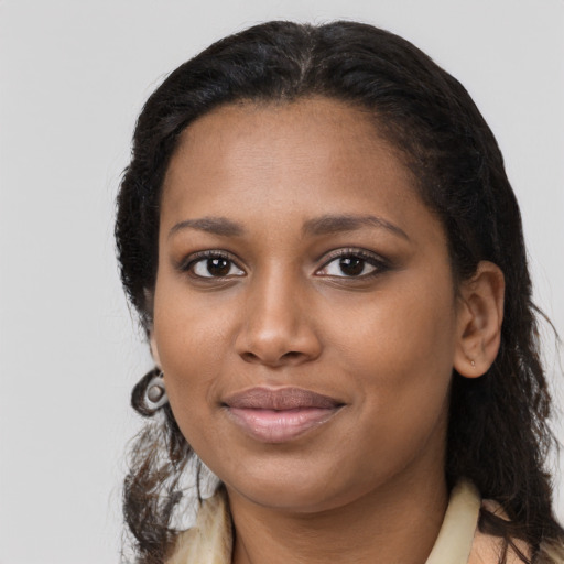 Joyful black young-adult female with long  black hair and brown eyes