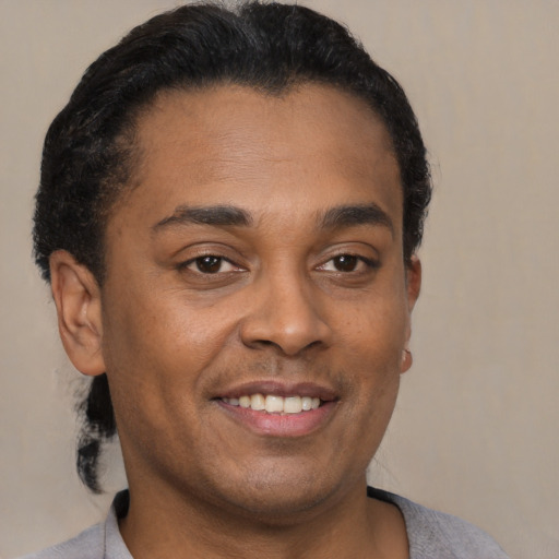 Joyful latino young-adult male with short  brown hair and brown eyes