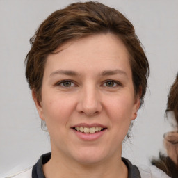 Joyful white young-adult female with medium  brown hair and grey eyes