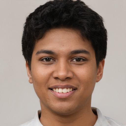 Joyful latino young-adult male with short  black hair and brown eyes