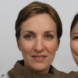 Joyful white adult female with medium  brown hair and grey eyes